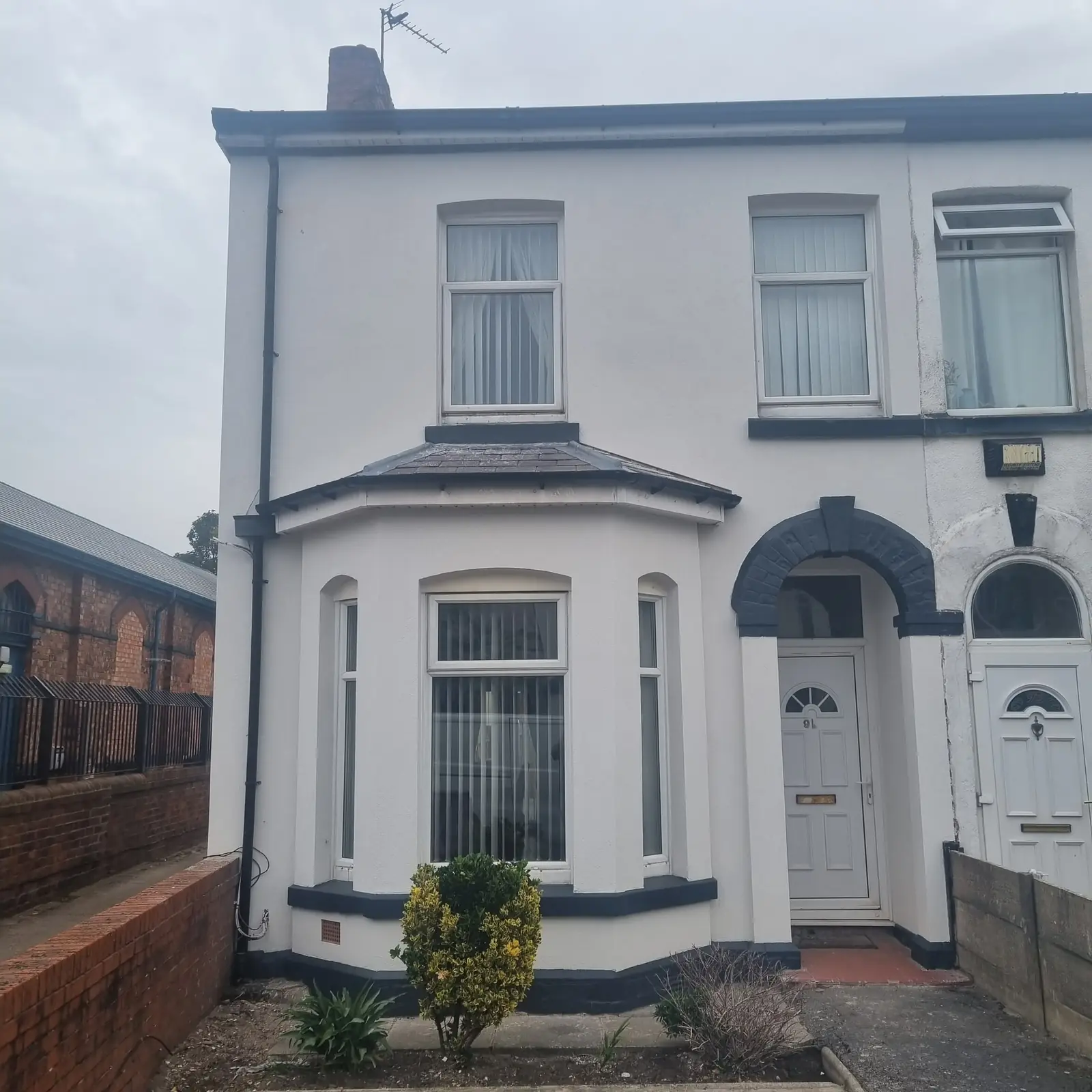 End terrace in Southport in white render with dark grey band details